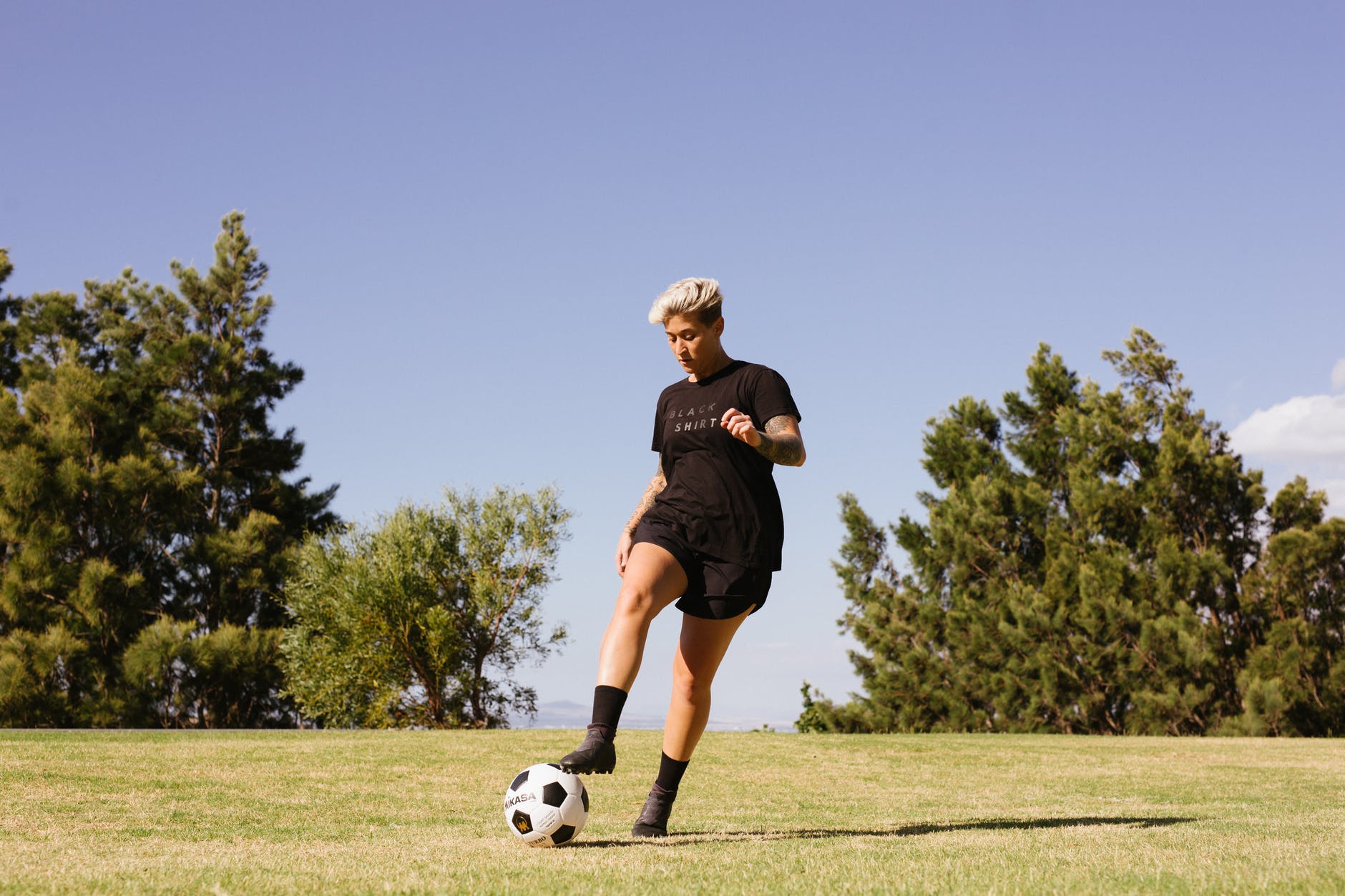 person wearing black shirt and shorts playing soccer